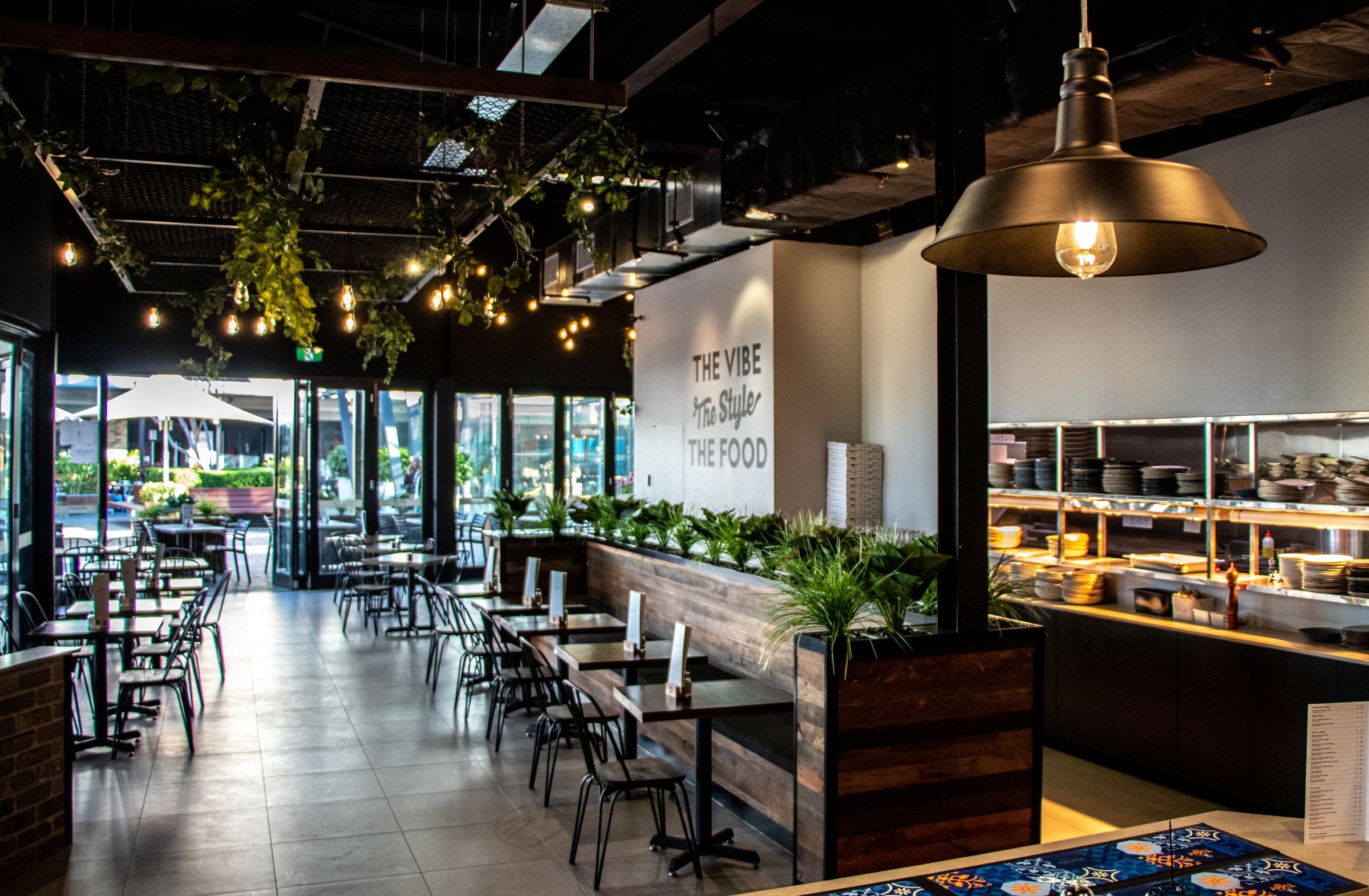 Contemporary restaurant fitout with greenery, pendant lighting and tables
