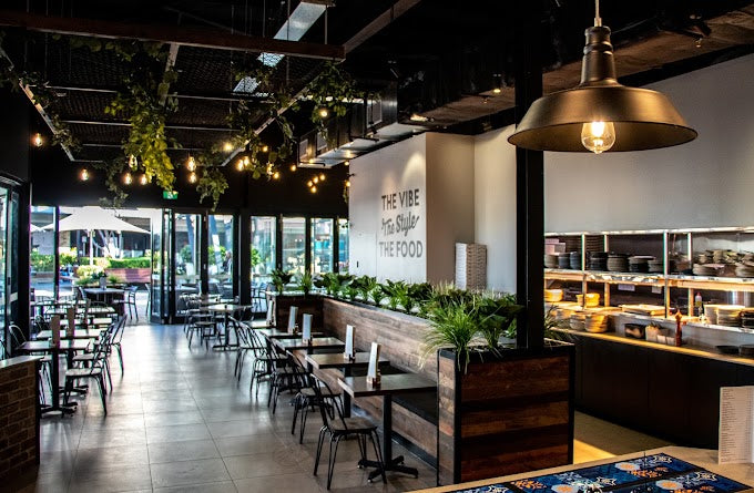 Hospitality fit-out with planted divider, tables and pendant lights