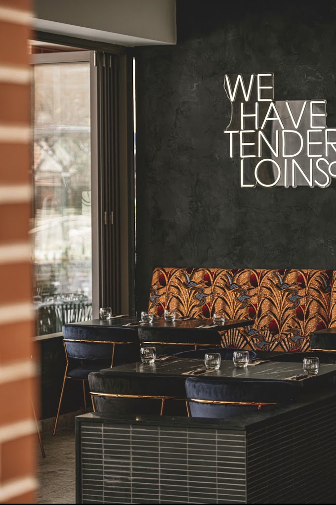 Completed hospitality dining space with custom seating, textured walls and lighting
